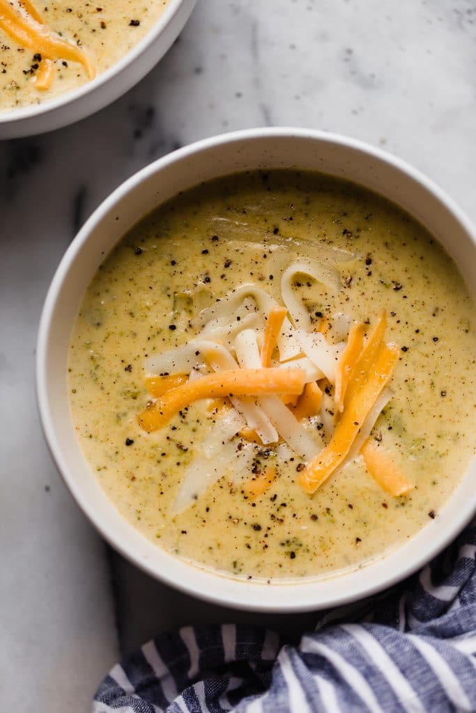 instant pot broccoli cheese soup garnished with more sharp cheddar cheese