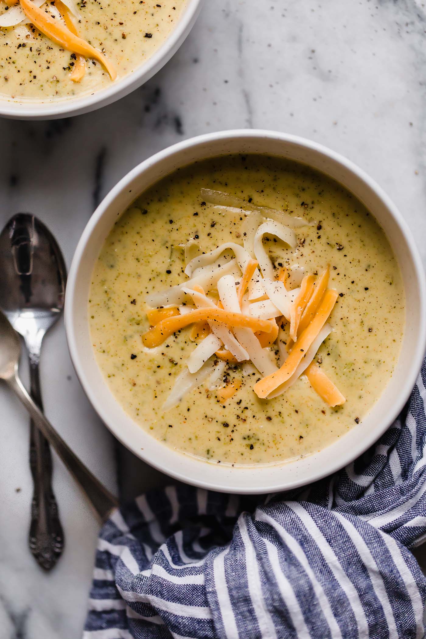 overhead shot of instant pot broccoli cheese soup in serving bowl beside spoon