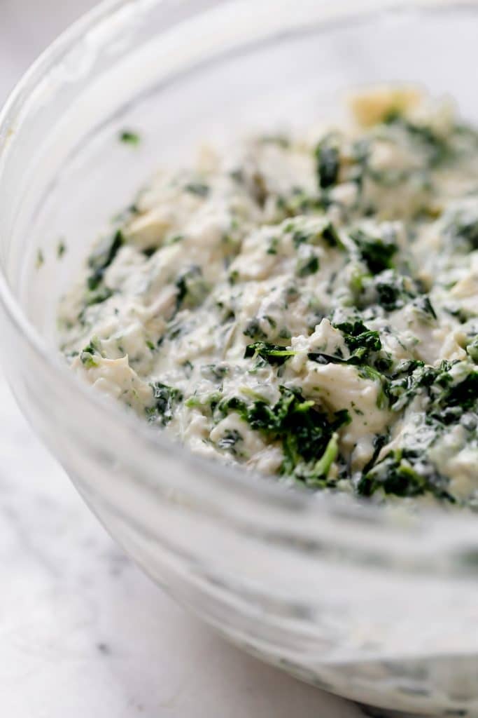 jalapeño spinach artichoke dip in a mixing bowl close up pre-bake