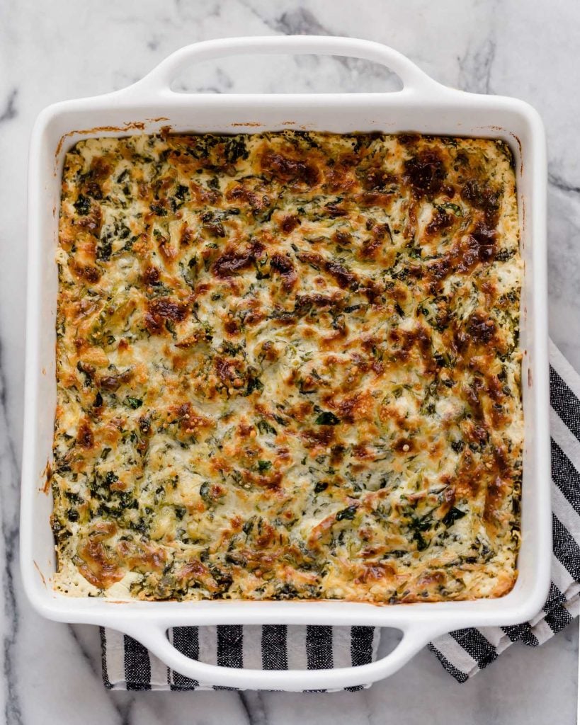 baked jalapeño spinach artichoke dip in a square oven-safe baking dish