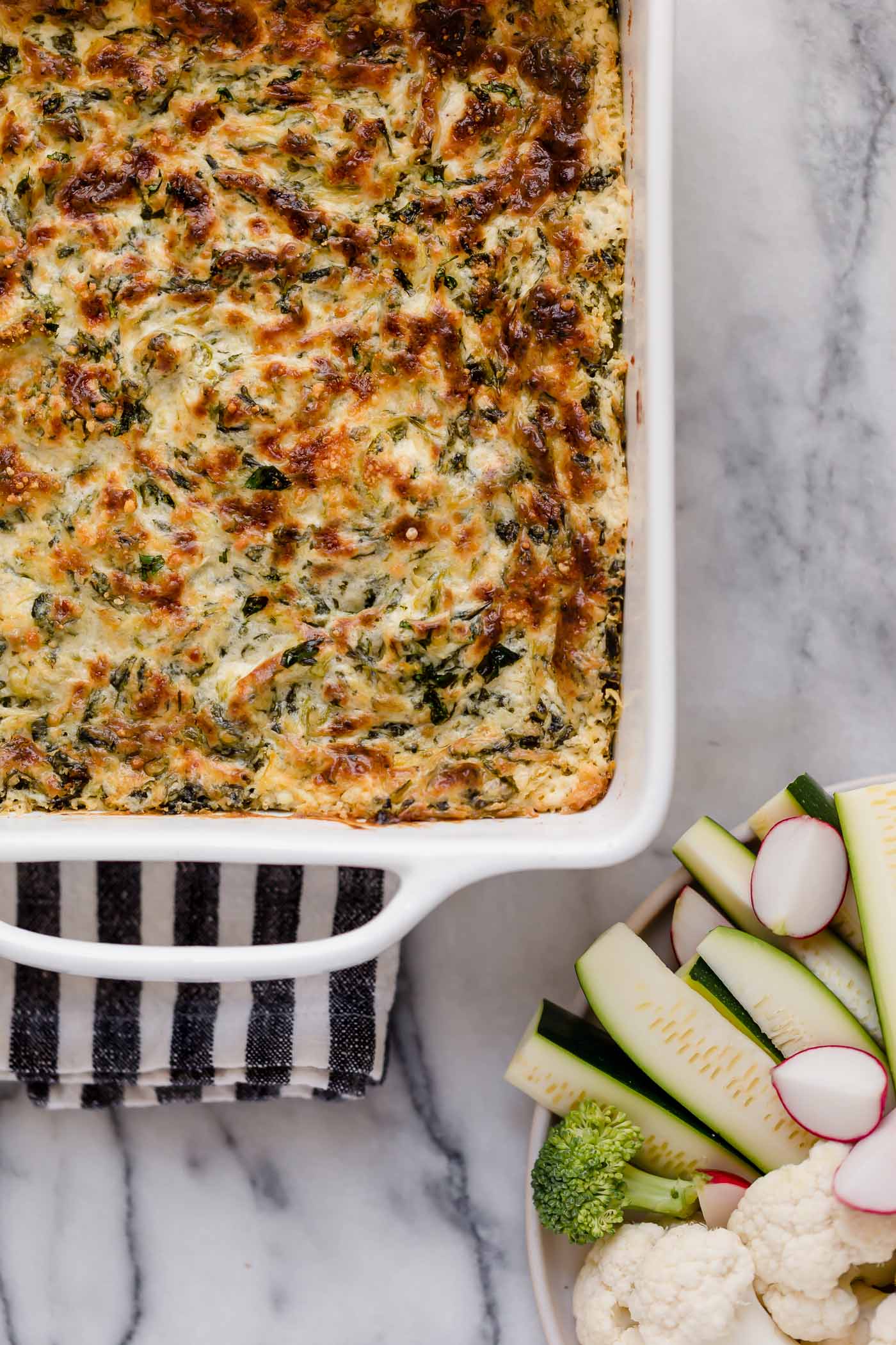 hero shot jalapeño spinach artichoke dip baked in a small square baking dish