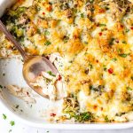 broccoli chicken casserole in an oval dish with a copper spoon