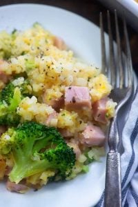 closeup of one serving of ham casserole with cauliflower rice on white plate with fork