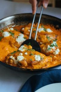 Keto chicken thighs in a skillet with spatula