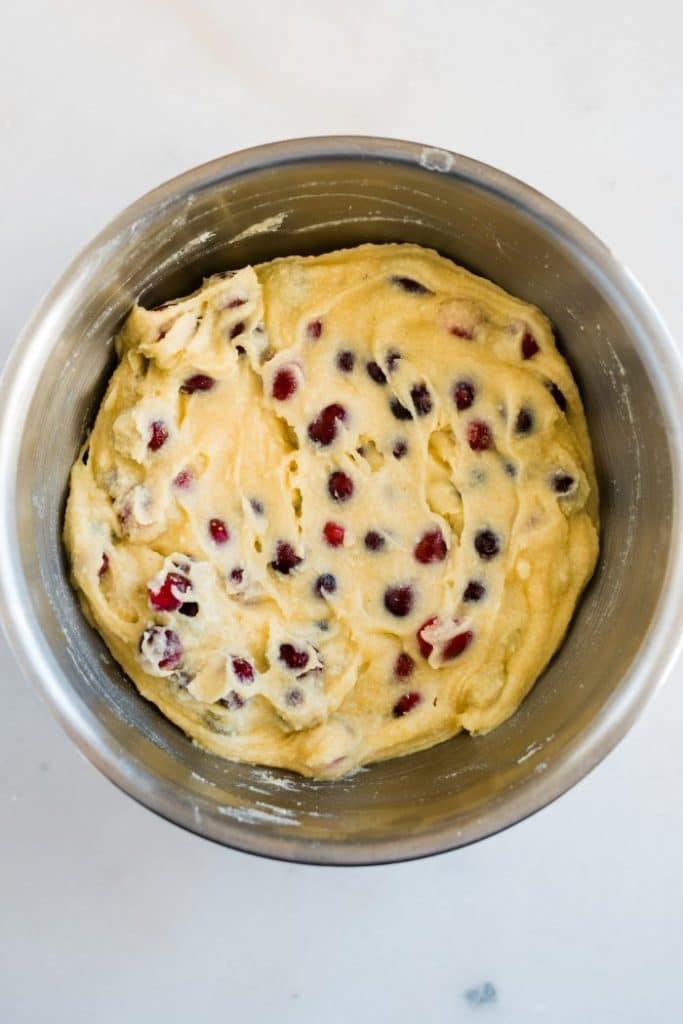 cranberries gently folded into keto muffin batter in a large mixing bowl
