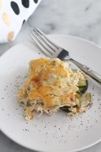 1 serving of cheesy zucchini chicken casserole on white plate with fork