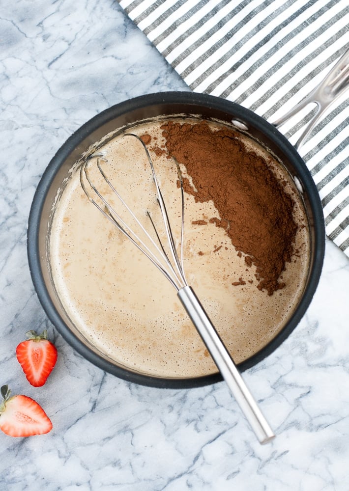 cocoa powder and strawberry extract poured into heated mixture of heavy cream, monk fruit sweetener, gelatin powder, and espresso powder in a saucepan