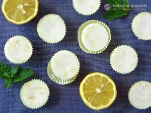 Easy Lemon Fat Bombs in tiny macaroon paper cups beside peppermint leaves and lemon slices