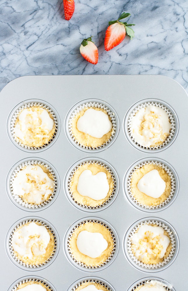 low carb coconut muffin batter scooped into muffin tins with cream filling