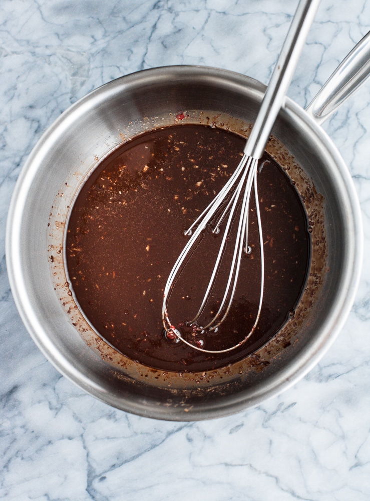mashed raspberries, melted cocoa butter, cocoa powder, shredded coconut, monk fruit sweetener, and vanilla extract whisked in a stainless steel saucepan