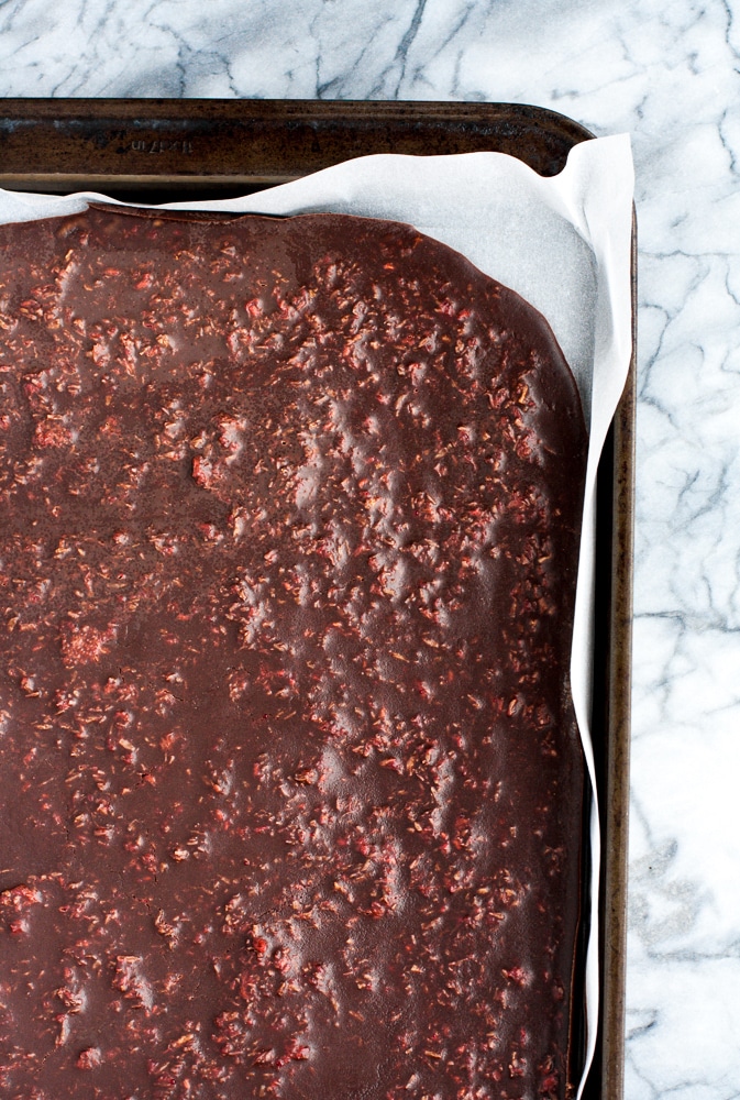 solidified dark raspberry chocolate mixture poured onto a baking sheet lined with parchment paper