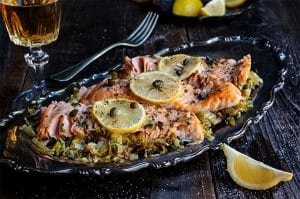 Baked Salmon with Creamy Leeks beside lemon wedges