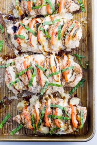 Caprese Hasselback Chicken on a baking pan