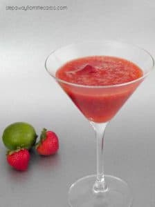 one serving of Low Carb Strawberry Daquiri beside two strawberries and a lime