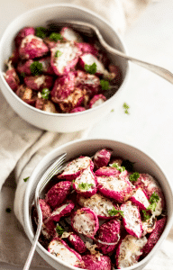 two bowls of keto roasted radishes with forks garnished with parsley leaves