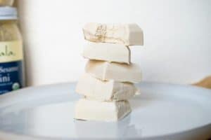 five pieces of Vanilla Tahini Keto Fudge stacked on top of each other 