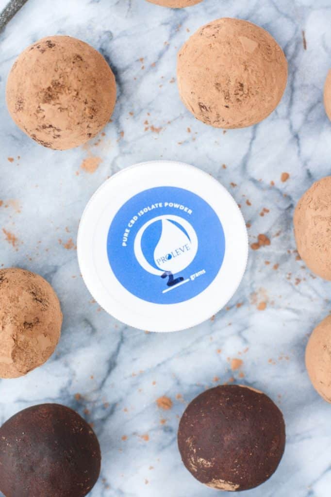 Chocolate Truffle Fat Bombs surrounding Proleve pure CBD isolate on a marble counter