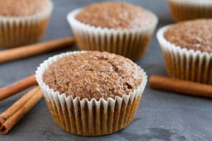 flaxseed cinnamon bun muffins beside cinnamon sticks