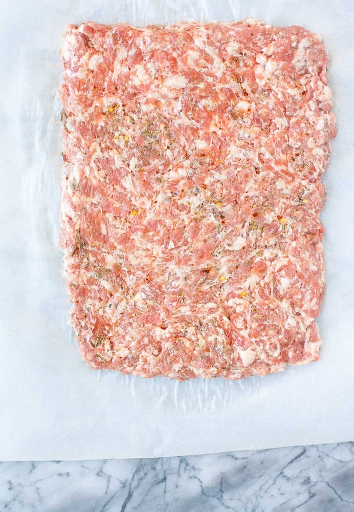 ground pork mixture on a sheet of parchment paper formed into a rectangle