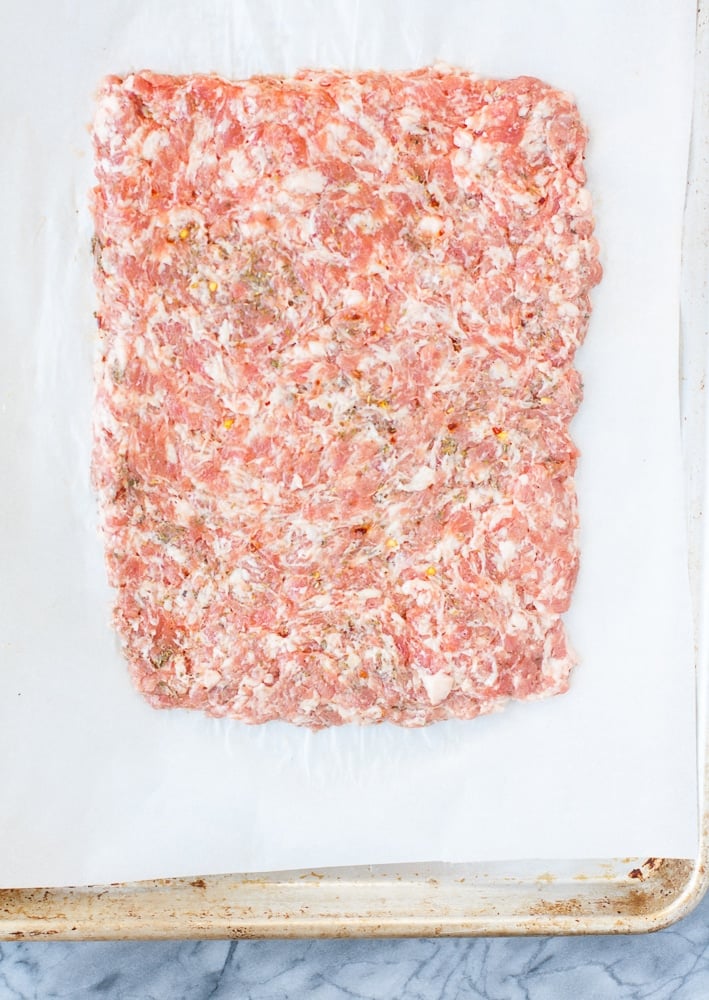 ground pork mixture on a sheet of parchment paper formed into a rectangle on a baking sheet