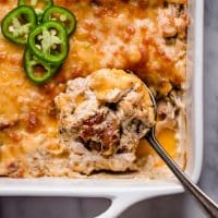 Jalapeño Popper Chicken Casserole in a baking dish scooped with spoon