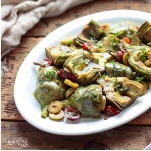 marinated baby artichokes antipasto salad served on an oval dish