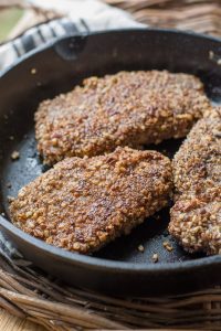 pecan crusted pork chops in a cast iron skillet