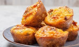 keto egg muffins with bacon and cheese piled on a plate