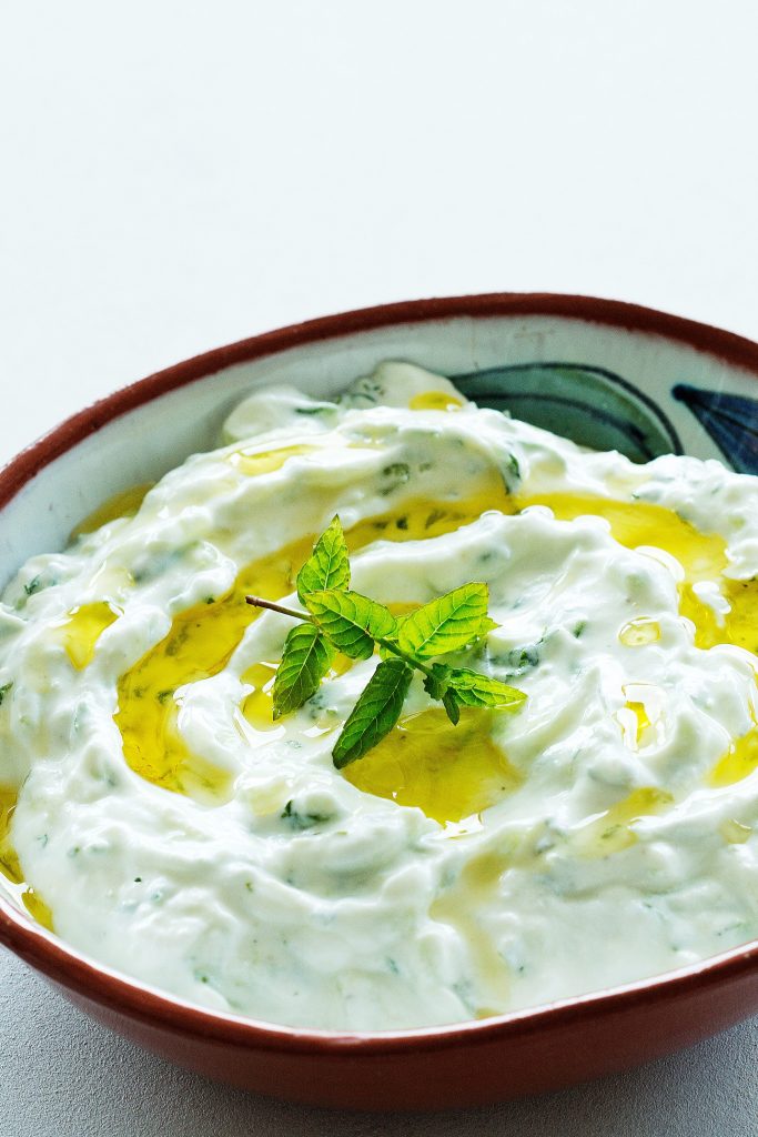 tzatziki dip drizzled with olive oil and fresh basil