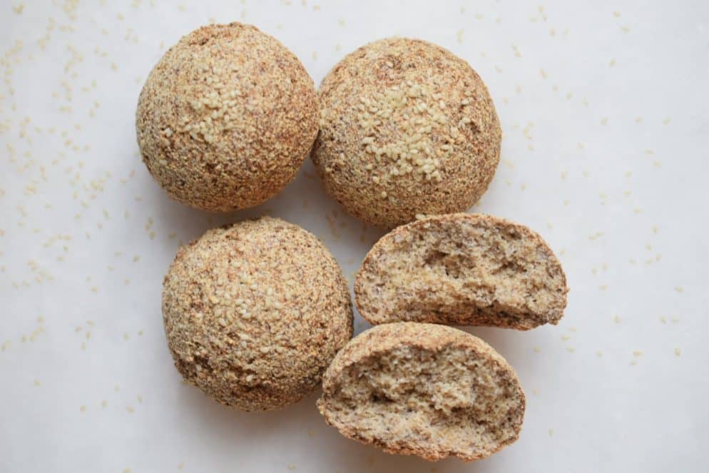 4 nut-free keto bread rolls with one broken in half
