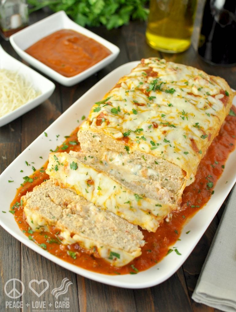 stuffed chicken parmesan meatloaf partially sliced and topped with cheese