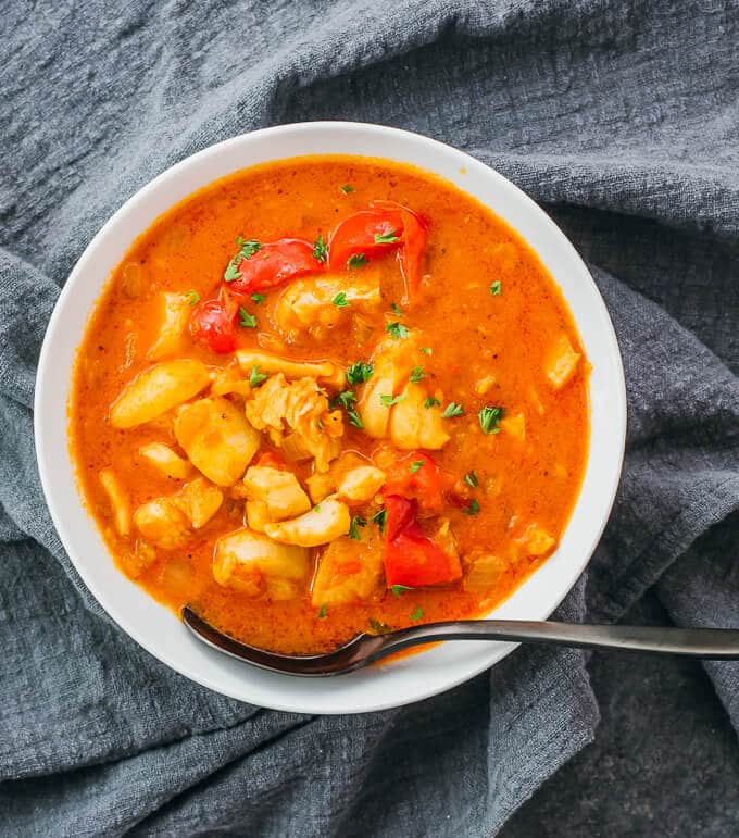 bowl of instant pot fish stew atop a gray cloth