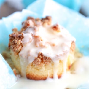 keto lemon sour cream muffin with glaze and on a light blue wrapper