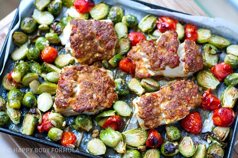 paleo cod on a sheet pan surrounded by veggies