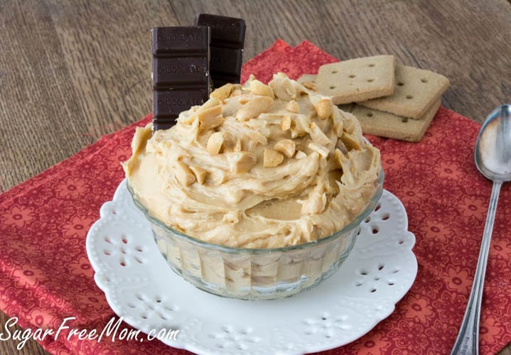 glass bowl heaping with peanut butter cheesecake dip and chocolate squares