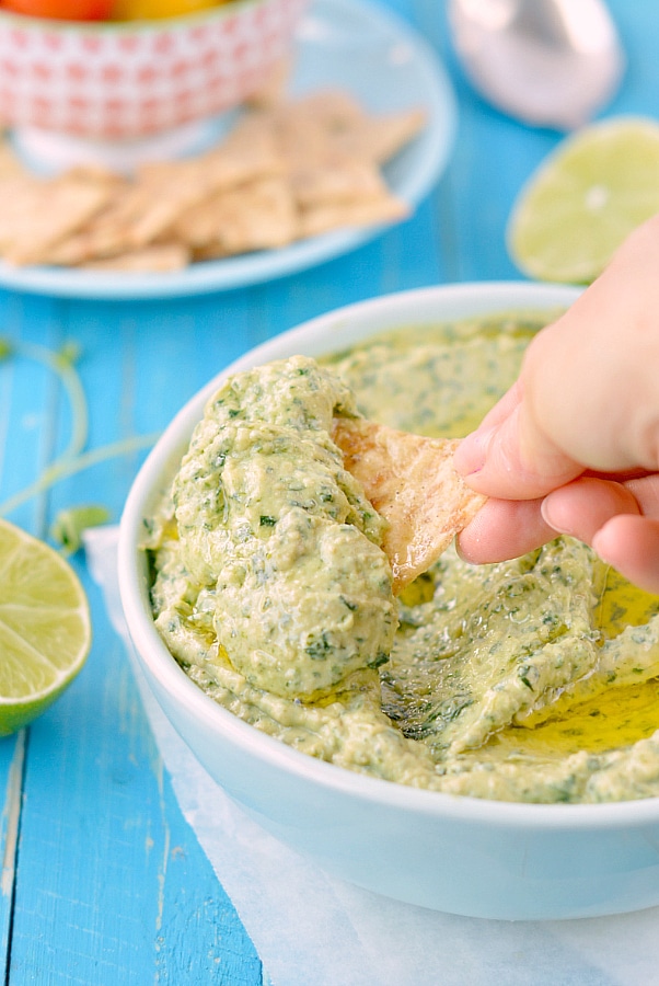 chip being dipped into avocado spinach dip