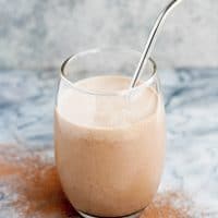 hero shot of chocolate fat bomb smoothie in a glass atop a marble kitchen counter