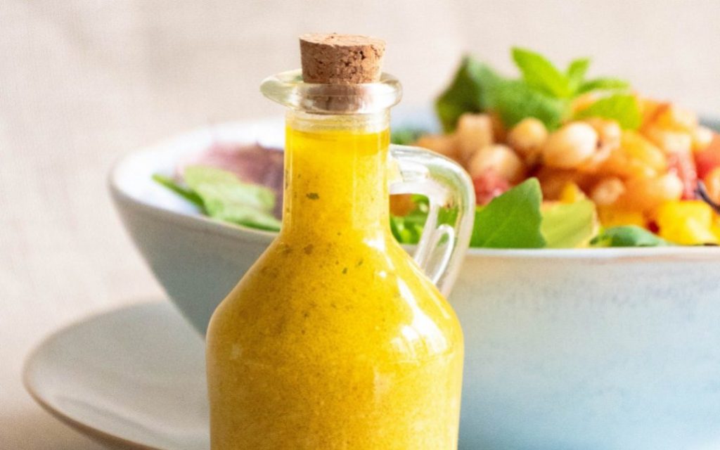 apple cider vinegar salad dressing in a glass pouring container