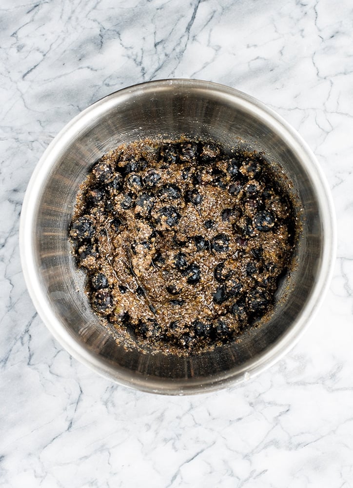 crumble mixture in a stainless steel mixing bowl atop a marble counter top