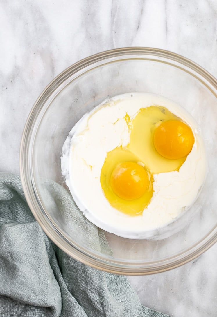 a medium bowl with eggs and heavy whipping cream