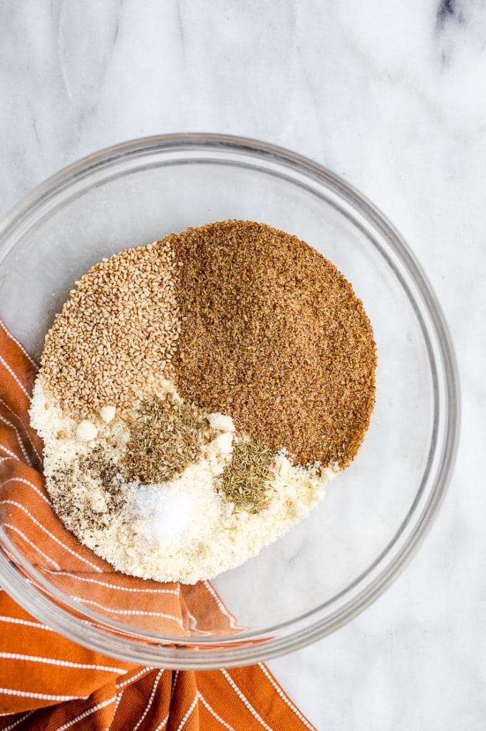 keto cracker dry ingredients in a glass mixing bowl atop a marble kitchen counter