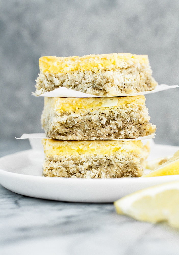 hero shot of keto lemon bars stacked on top of each other on a plate atop a marble kitchen counter