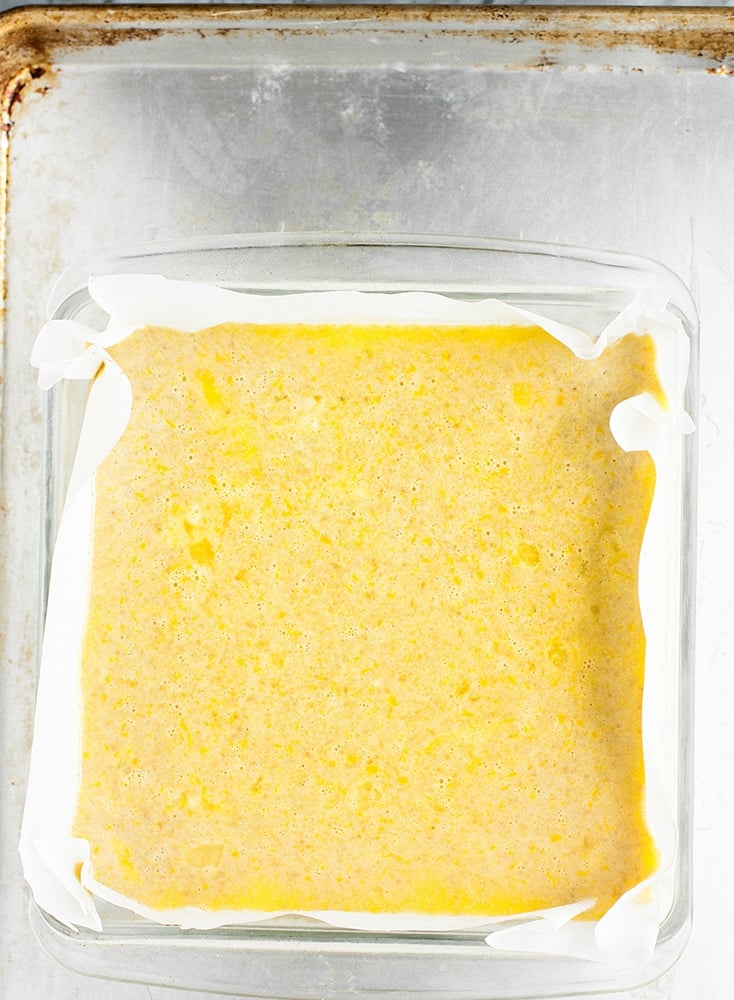 lemon bar mixture poured atop crust in a baking dish