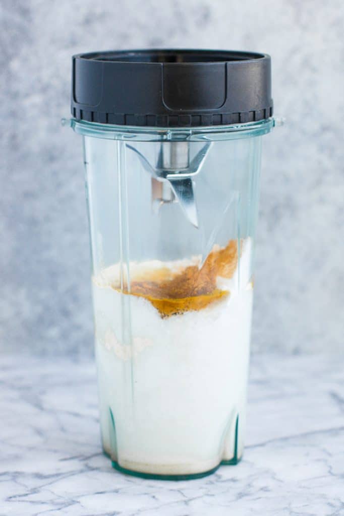 upside down food processor cup with smoothie ingredients atop a marble kitchen counter