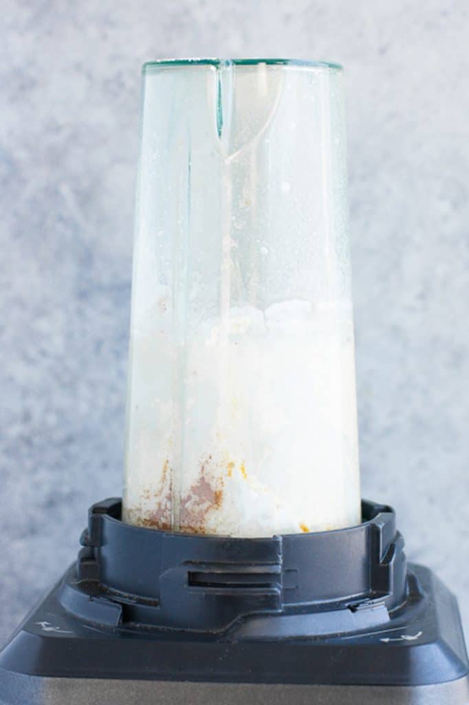 food processor pulsing smoothie ingredients atop a marble kitchen counter