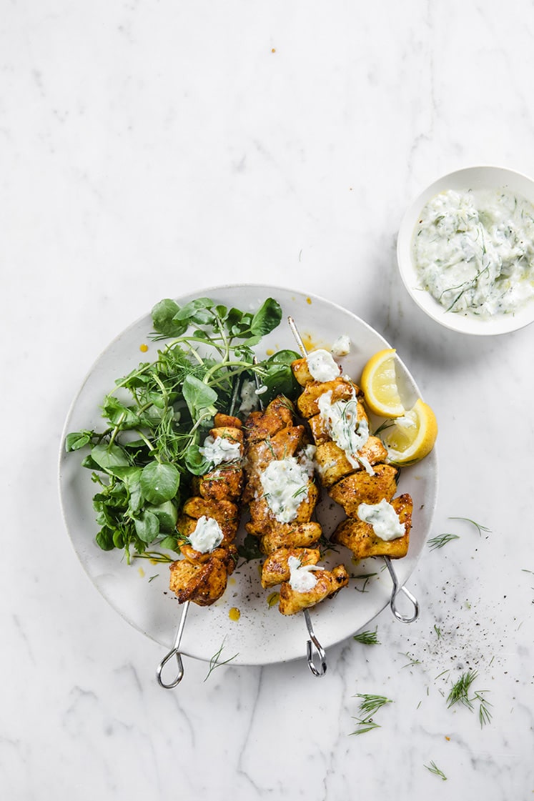 hero shot a plate of Chicken Shawarma Kebabs with Tzatziki served on a plate atop a marble kitchen counter