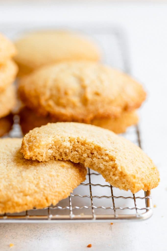 low carb cookies on a cooling rack with one bitten in half