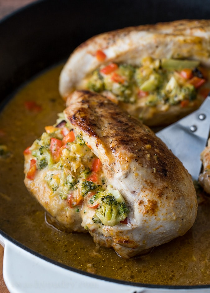 close up of broccoli cheese stuffed chicken breasts in pan