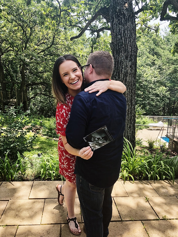 couple hugging for outdoor ultrasound photo for pregnancy announcement