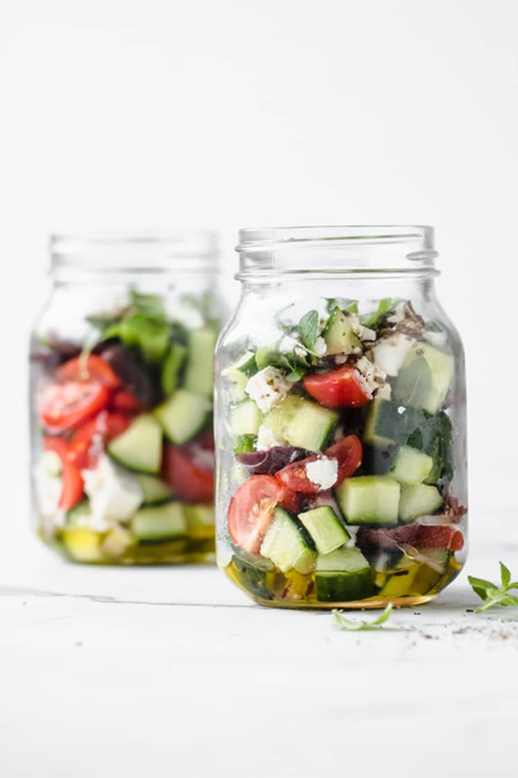 featured recipe image - 2 jars of low carb greek salad atop a marble kitchen counter